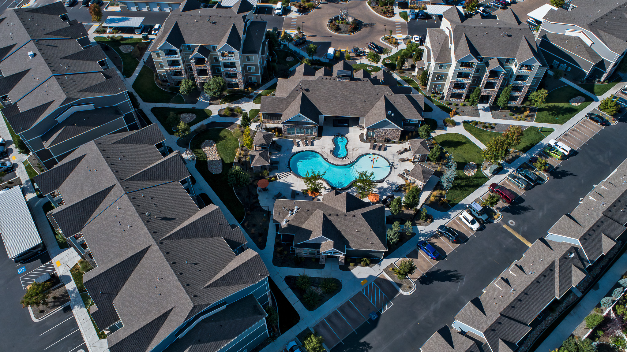 Aerial view of an apartment complex with a pool and clubhouse